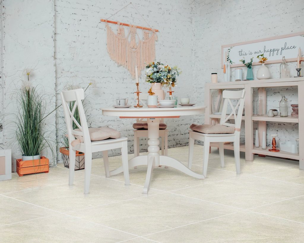 White dining room interior design. White round table with flowers, candles and cups.