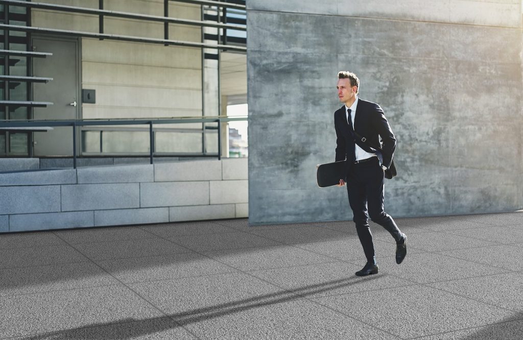 Young businessman with skateboard walking in rush